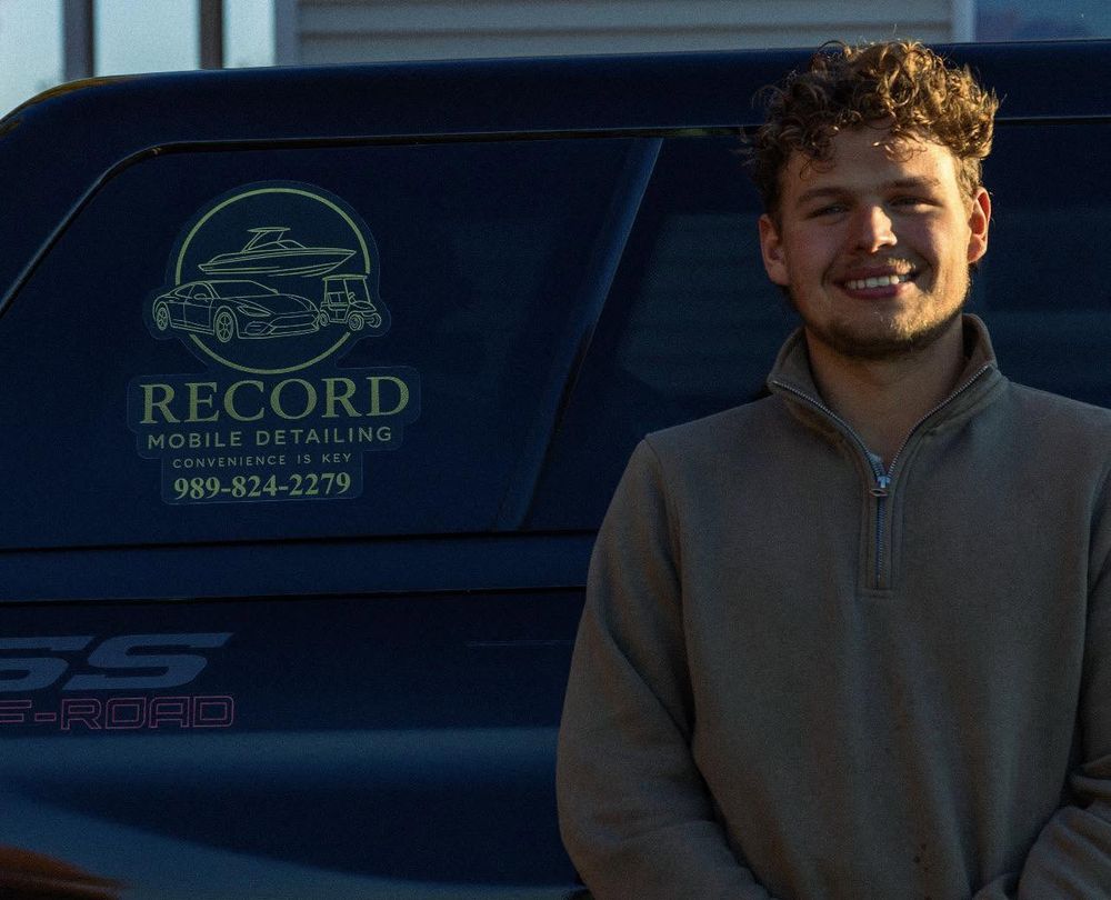 Carter Record standing beside his truck, which carries the Record Mobile Detailing logo and phone number on the window