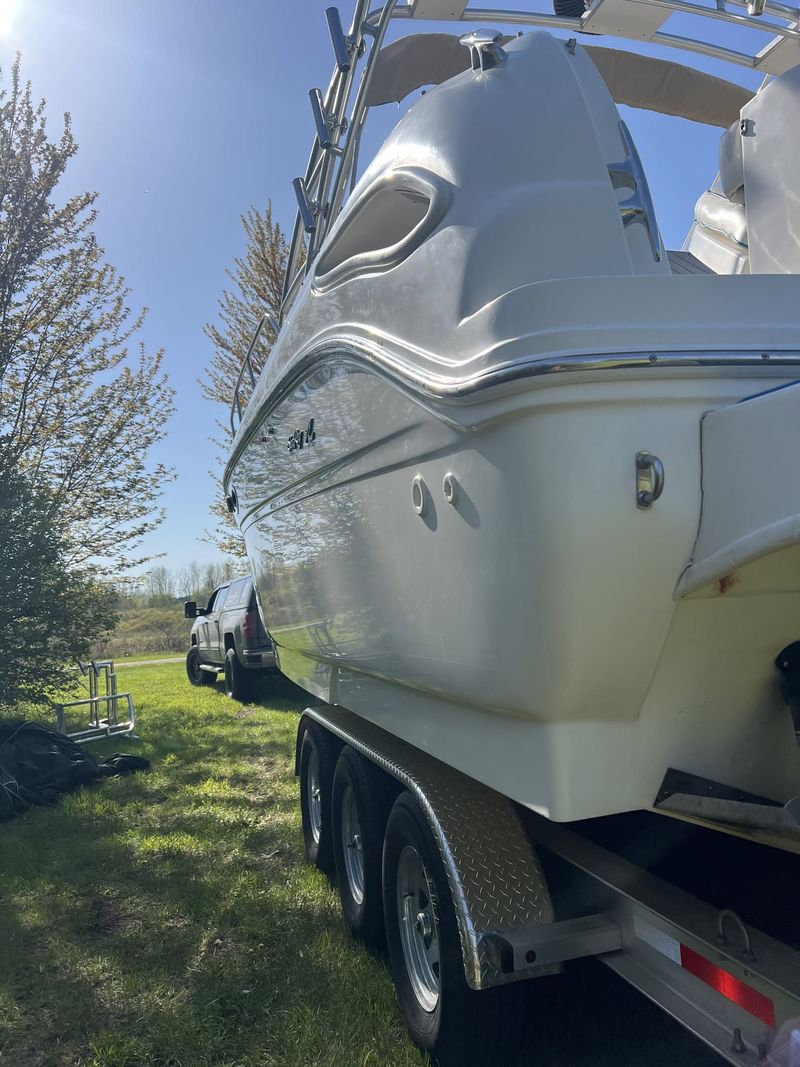 Large white cabin boat on a trailer after a full exterior detail