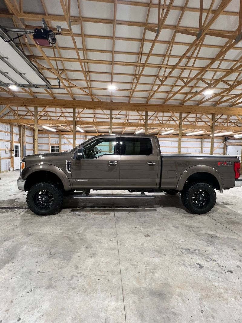 Lifted grey pickup truck detailed and parked inside a pole barn
