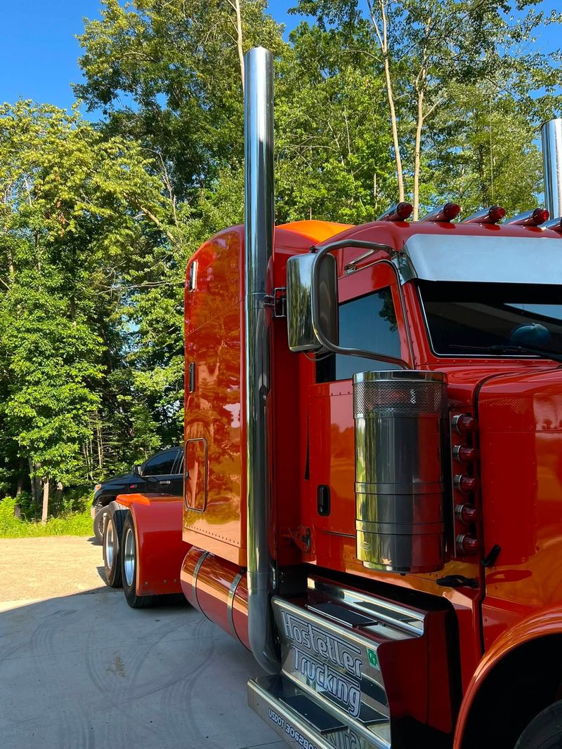 Red Peterbilt semi truck with polished chrome stacks