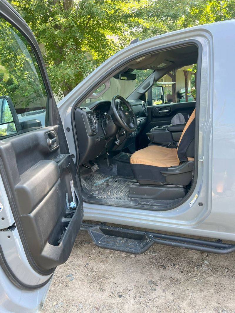 Front seats and door panel of a silver truck cleaned after an interior detail