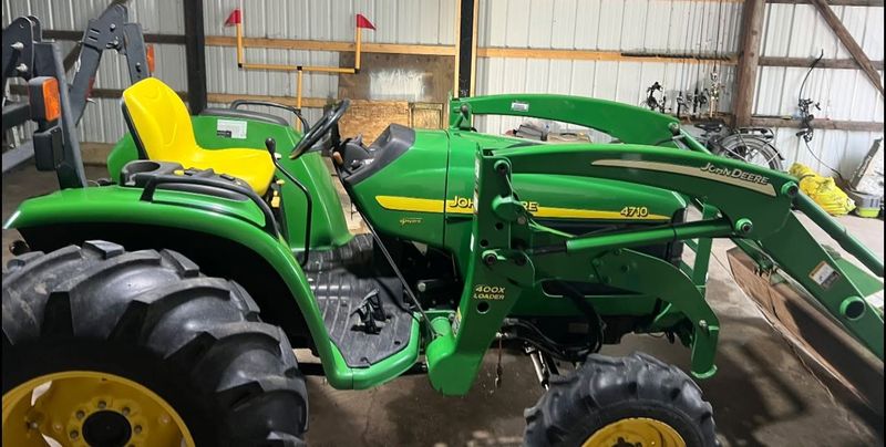 John Deere compact tractor with loader cleaned inside a machine shed